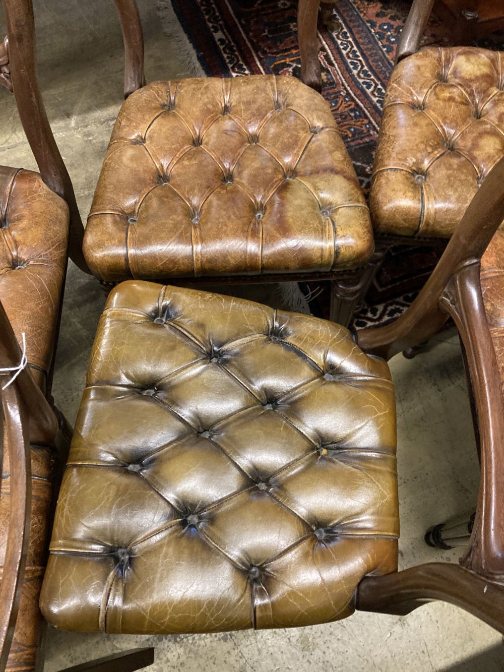 A set of six early Victorian mahogany dining chairs, with buttoned leather seats